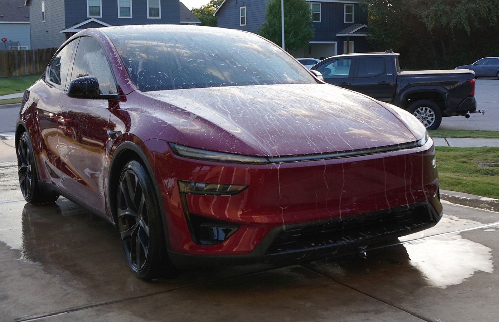 Freshly washed red Tesla Model Y with water beading on the paint after a detail by Archive Detailing in Georgetown, TX