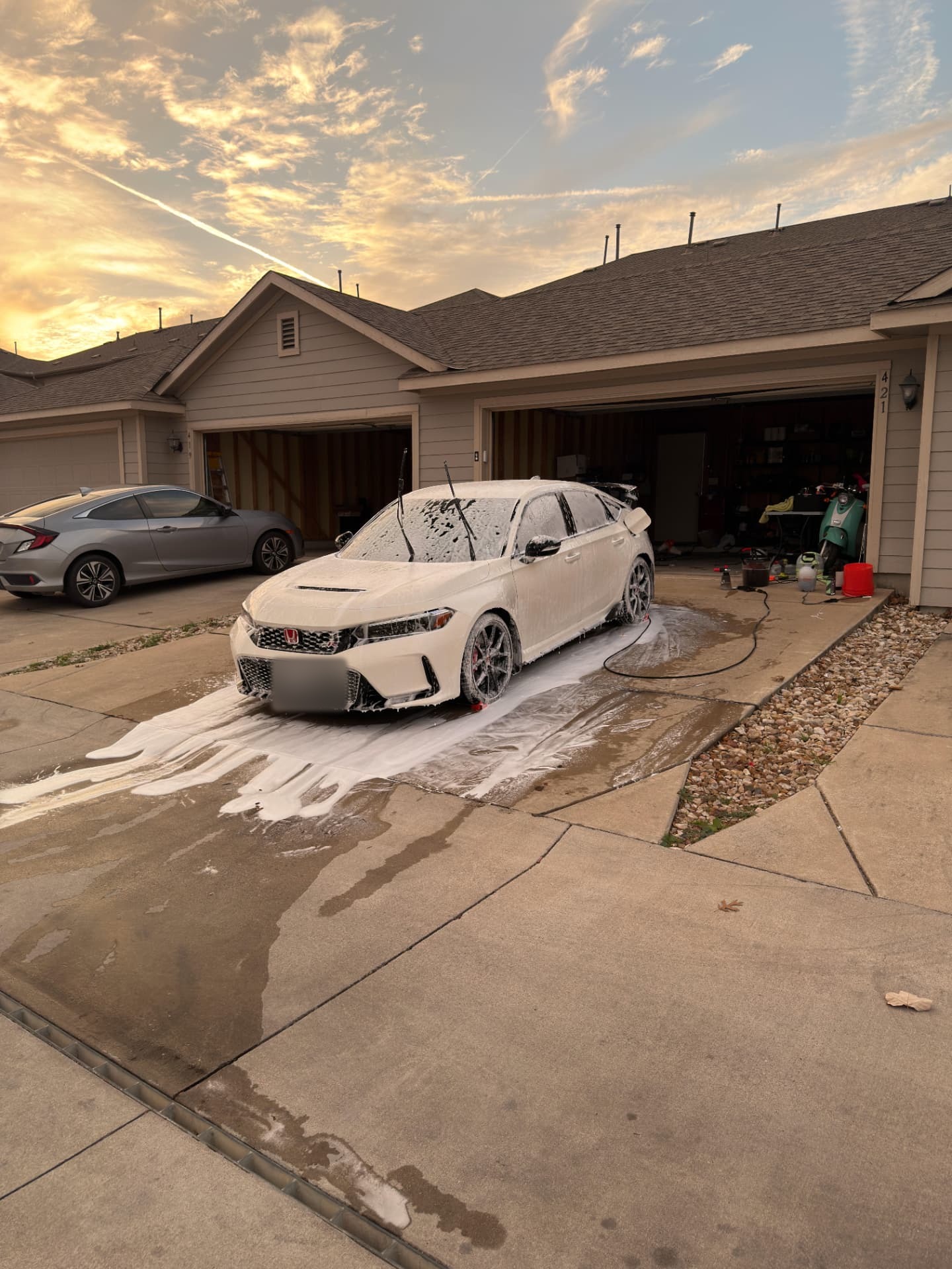 White performance sedan covered in thick foam during a safe hand wash